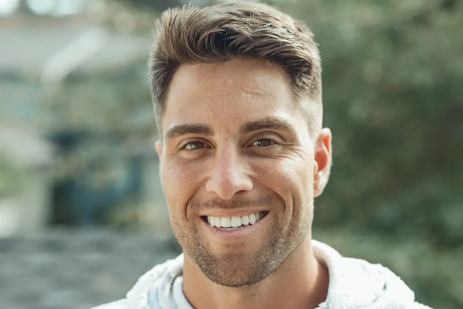 Man with an even, natural smile outdoors